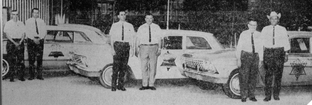 Sheriff Joe Faircloth and deputies posing with cars showing new Sheriff decal logo